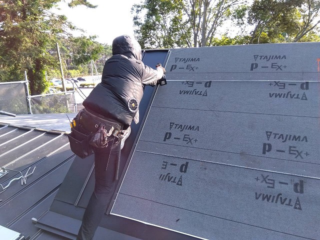 作業員が三角屋根部でデコルーフ本体の施工を行っている様子