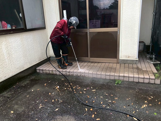 出入口前のタイルポーチを高圧洗浄している様子