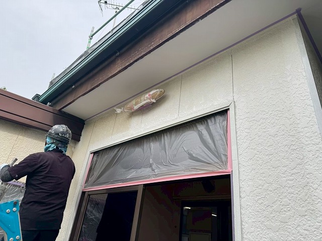 下塗りが進んだ外壁と塗装済みの軒天が見える施工状況
