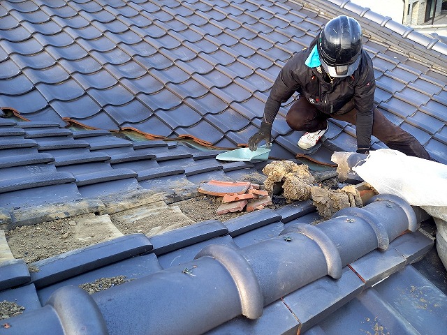 屋根葺き替え工事で棟の解体時にガラをゴミ袋に詰め込んでいる様子