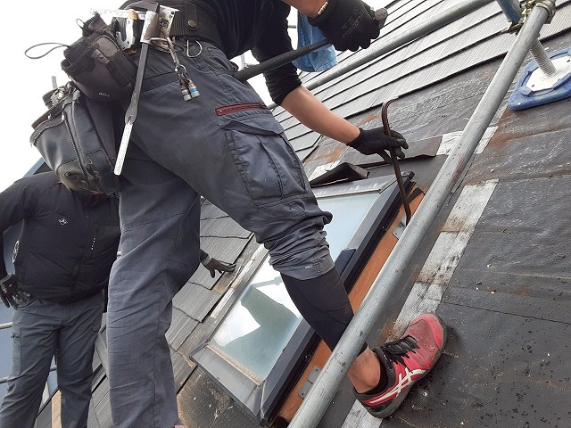 トップライト撤去工事の既設トップライトの本体をバールで解体している状況