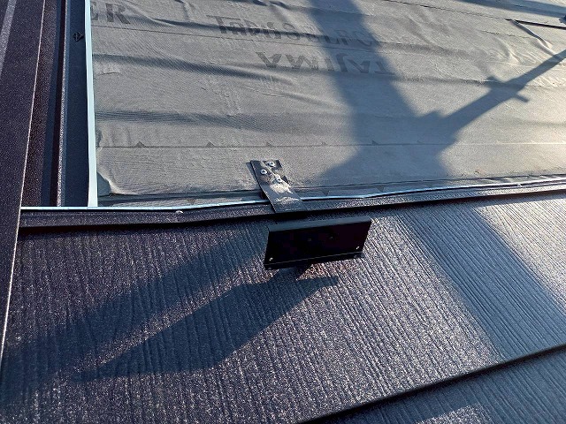 カバー工法による屋根改修工事の雪止め金具へのビス留め状況