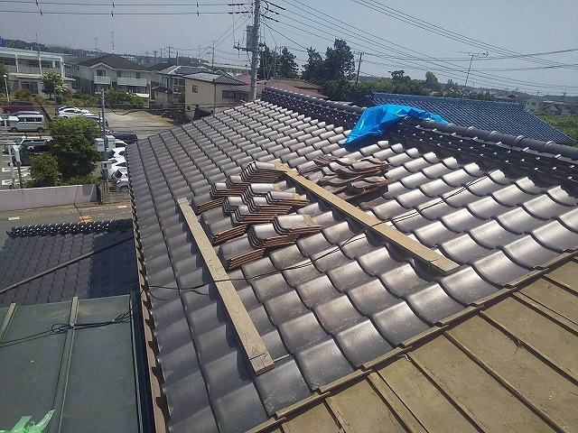 雨漏り修理のために取り外した瓦を積み重ねている屋根の全景