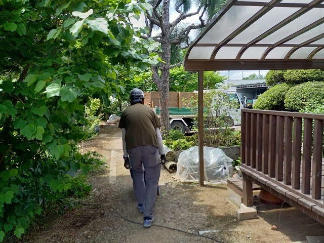 処分する瓦屋根を手押し車に乗せて運搬車両まで移動