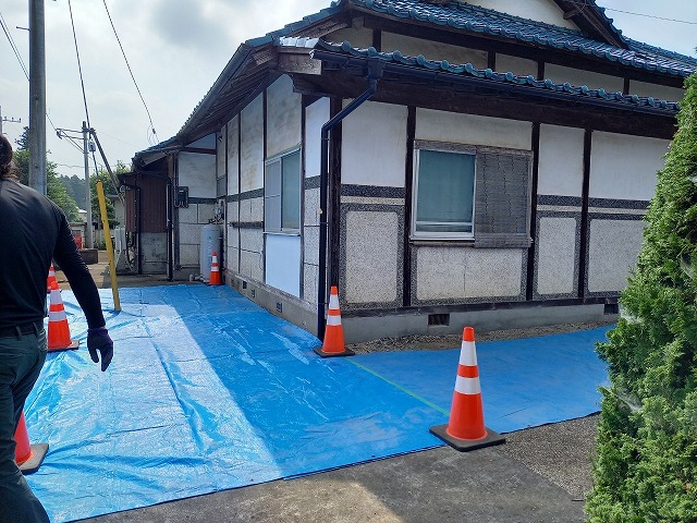 屋根葺き替え工事のためのブルーシートによる敷地養生