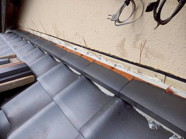 屋根葺き替え工事の下屋根と外壁との取り合い部へののし瓦1段目設置