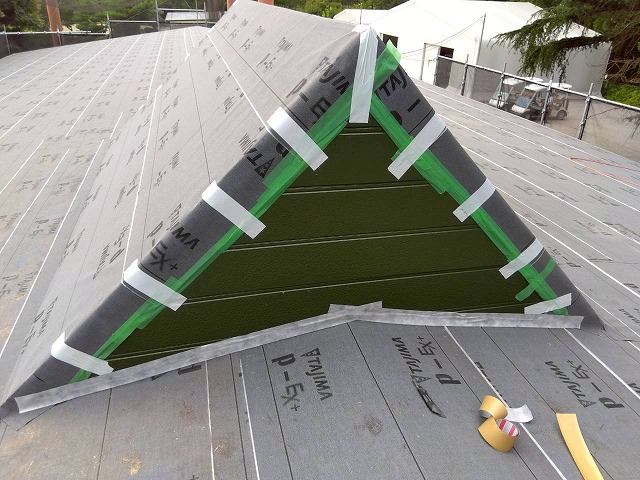 三角屋根に敷設した防水シートをテープで密着させた様子