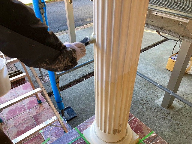 ポーチ柱を塗装する職人