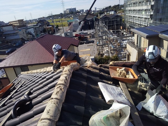 屋根の土を解体する職人たち
